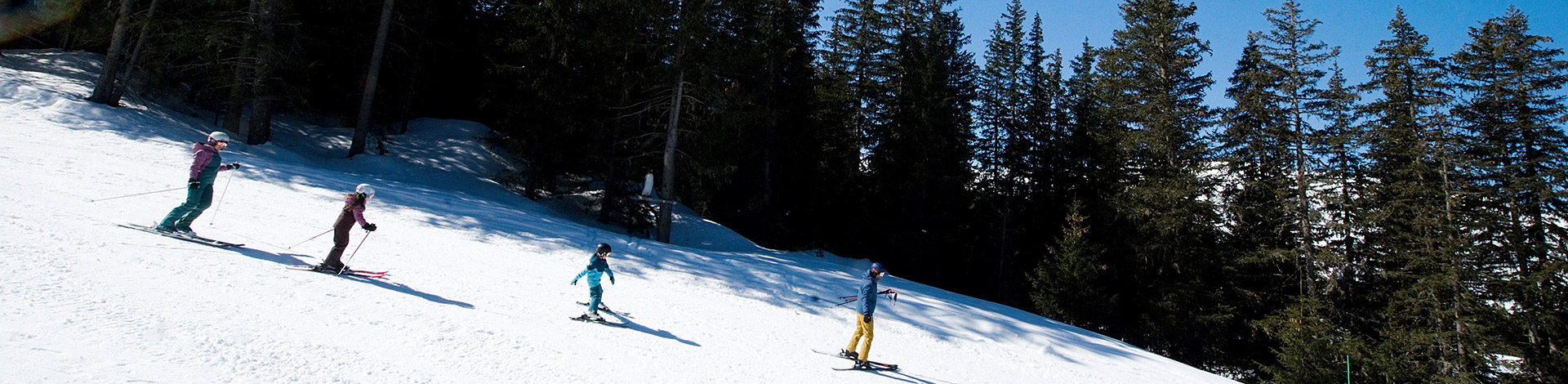 Famille au ski à Méribel dans Les 3 Vallées, dans la forêt du secteur de l'Altiport